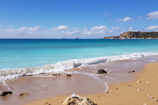 A turquoise blue sea and golden sand at Avithos Beach in Kefalonia, Greece